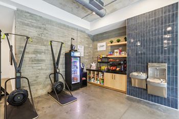 A room with a treadmill, a refrigerator, and a microwave.